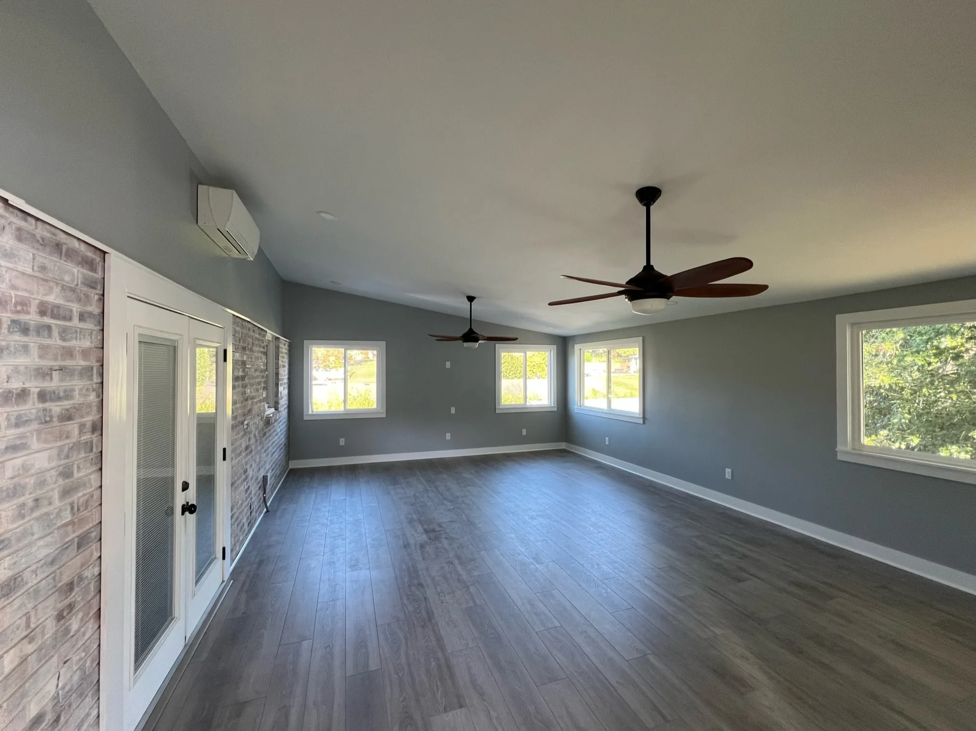 Renovated room with new wide plank floors and windows, part of a whole-home renovation by Southern Belle Construction