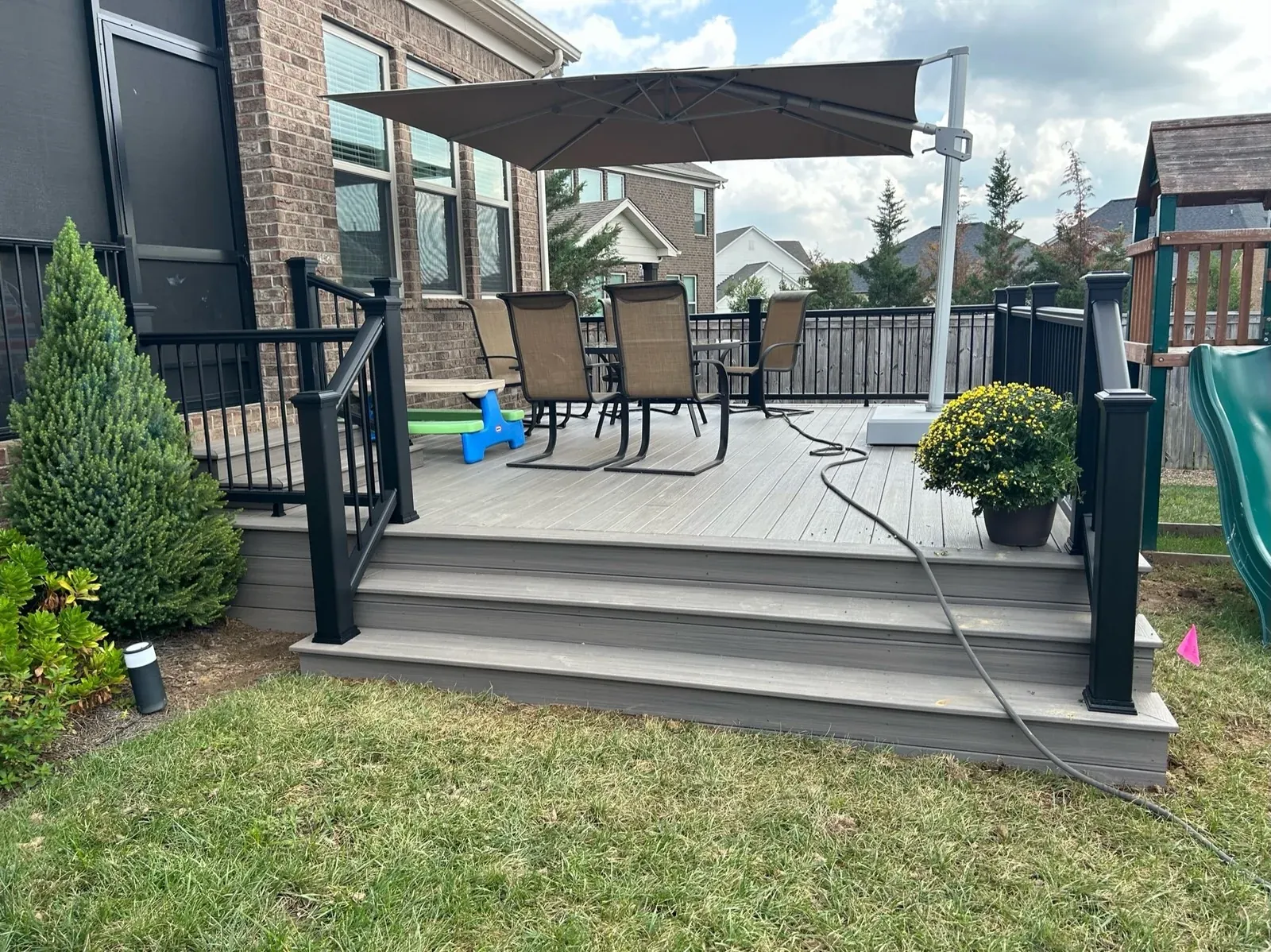 Gray composite deck with black aluminum railing and a cantilever umbrella
